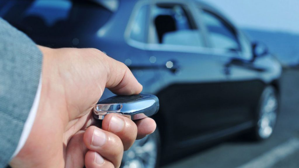 A man uses a factory remote starter fob to start his vehicle. 