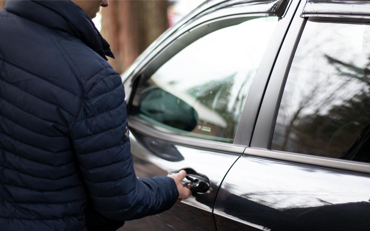 Person pulling on car door handle